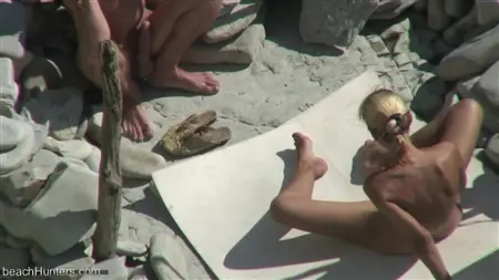 Blonde joue avec un membre de petit ami sur une plage nudiste