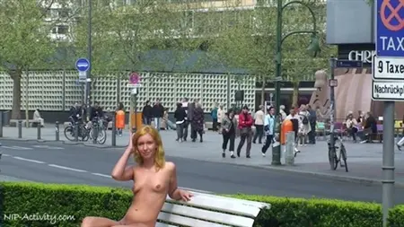 La fille s'est déshabillé publiquement parmi le parc