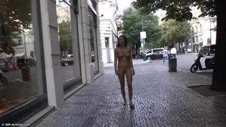 Promenade d'une brune nue dans le centre-ville