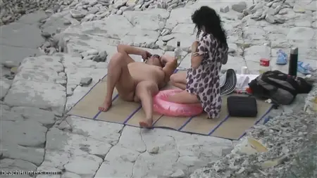 Des copines salopes avec des seins nus se détendent sur une plage déserte