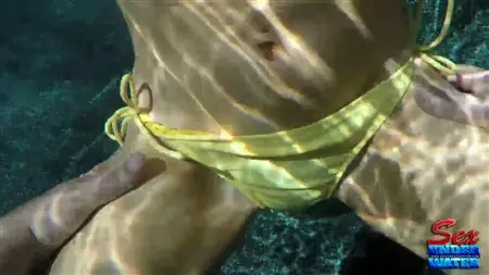 Une femelle en maillot de bain se masturbe sous l'eau