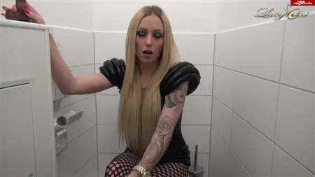 Exercices blonds tatoués avec un membre en caoutchouc dans les toilettes