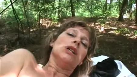 Une femme mature dans la forêt montre ses charmes et baise avec un homme
